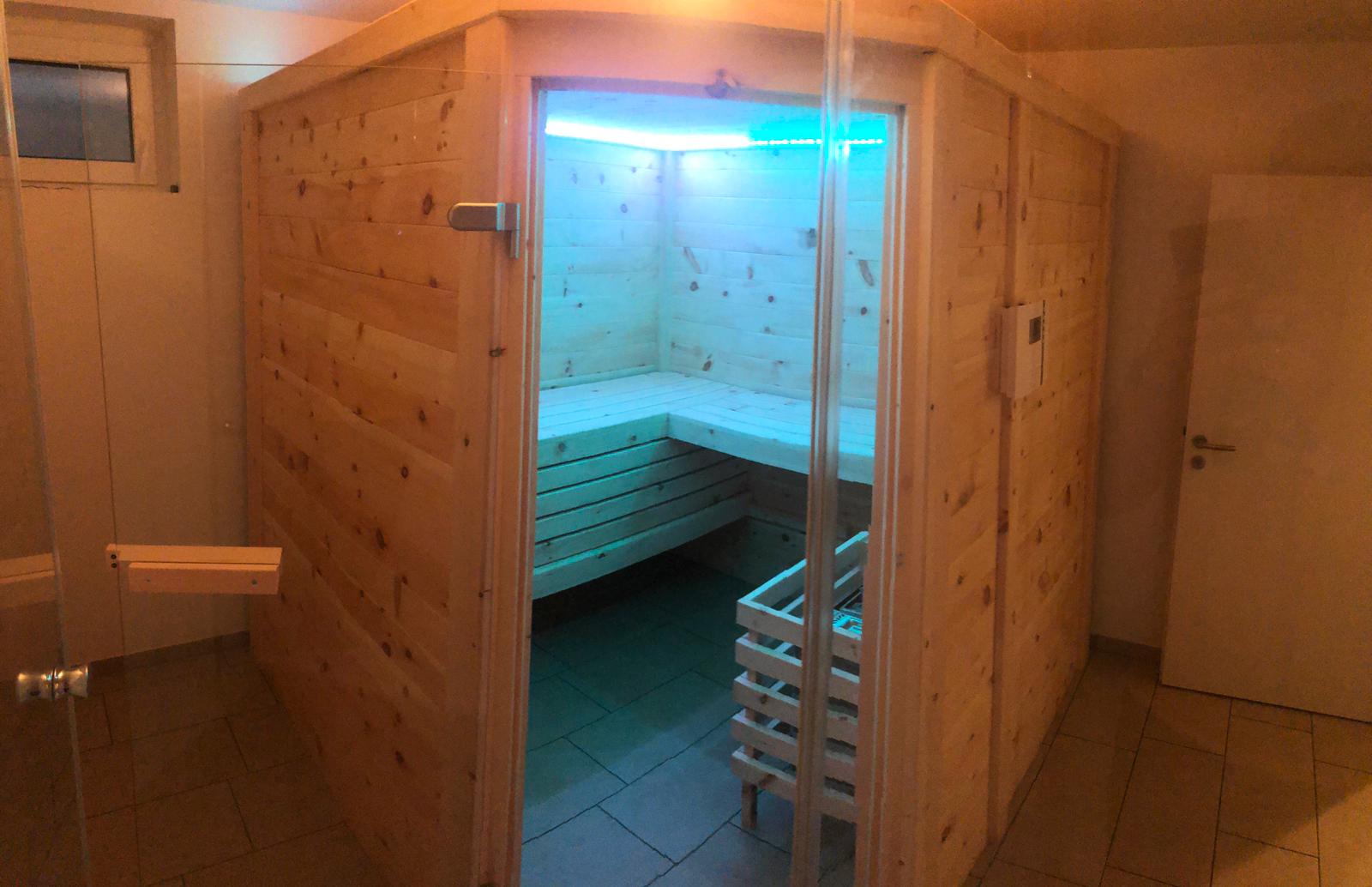 Sauna aus Zirbenholz mit blauer Beleuchtung