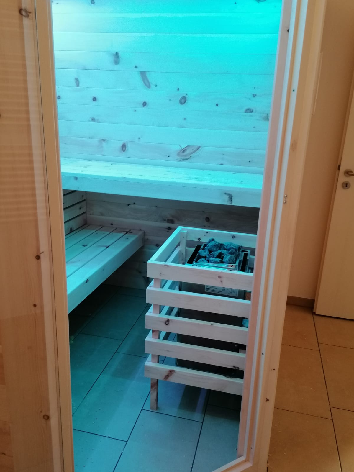 Sauna aus Zirbenholz mit blauer Beleuchtung
